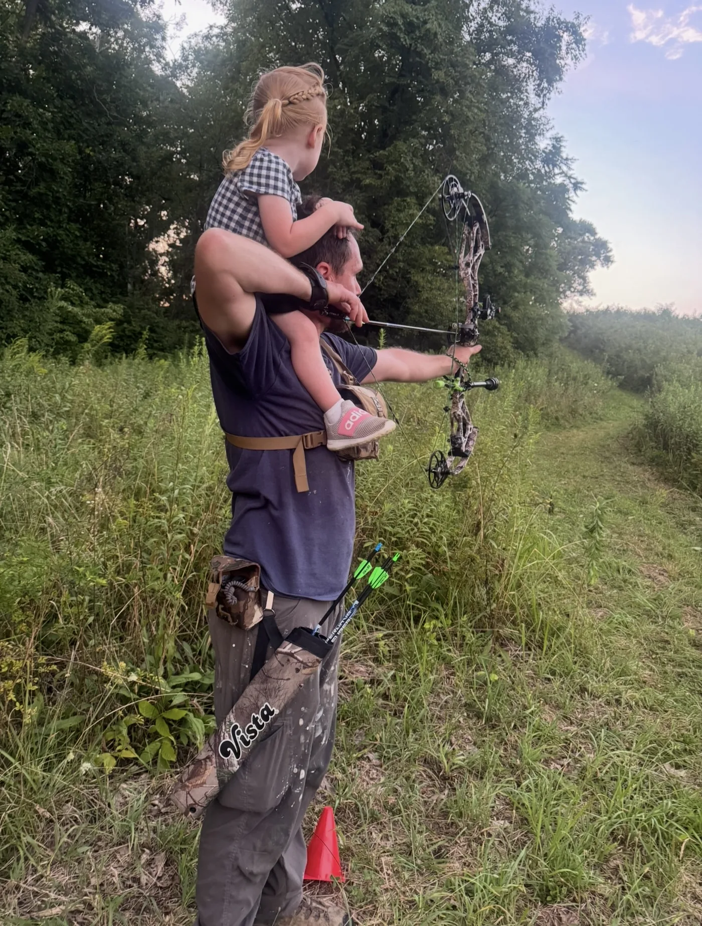 A father and daughter at full draw together